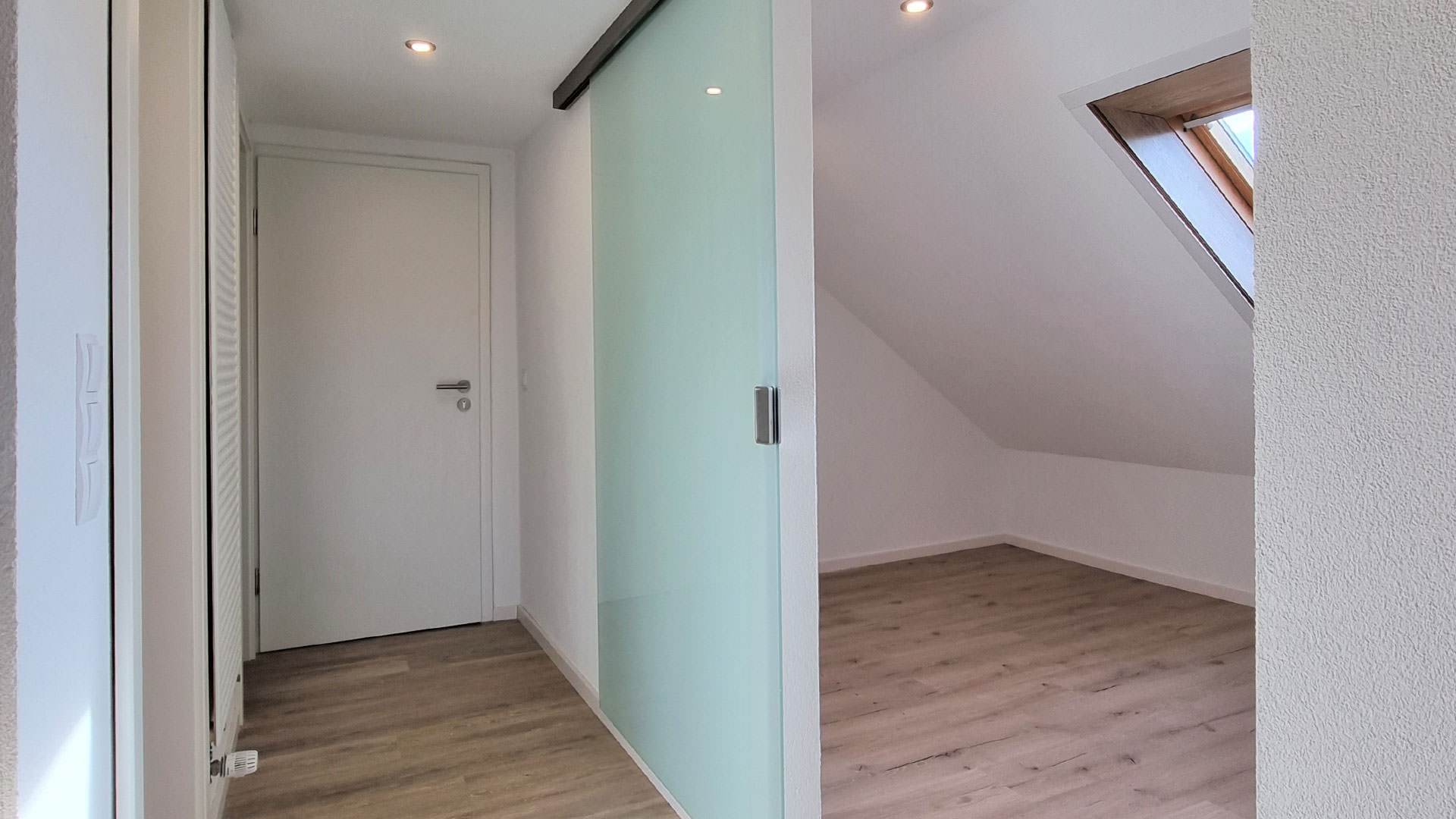 Flur und Zimmer, getrennt mit einer Glasschiebetür