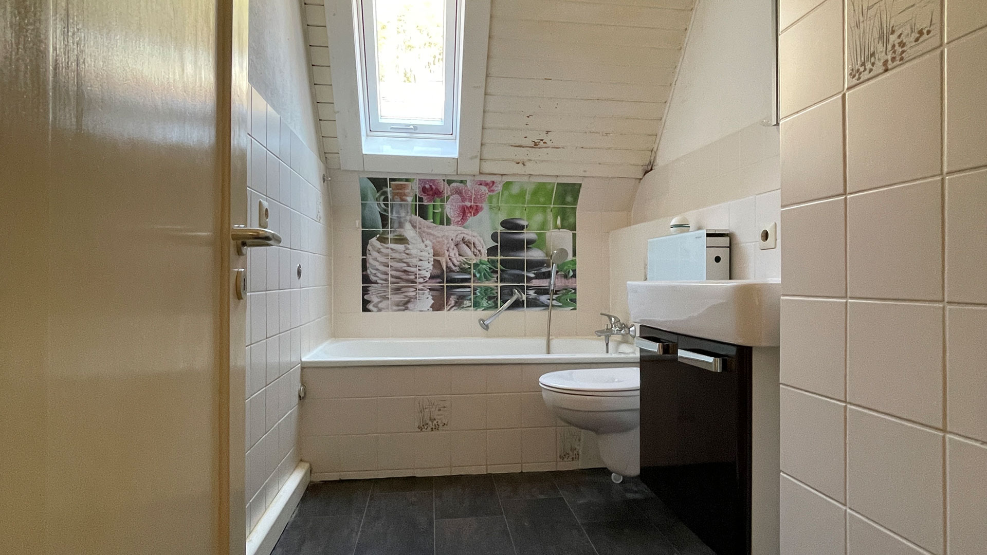 Bad mit Badewanne, Toilette und Waschbecken vor der Renovierung